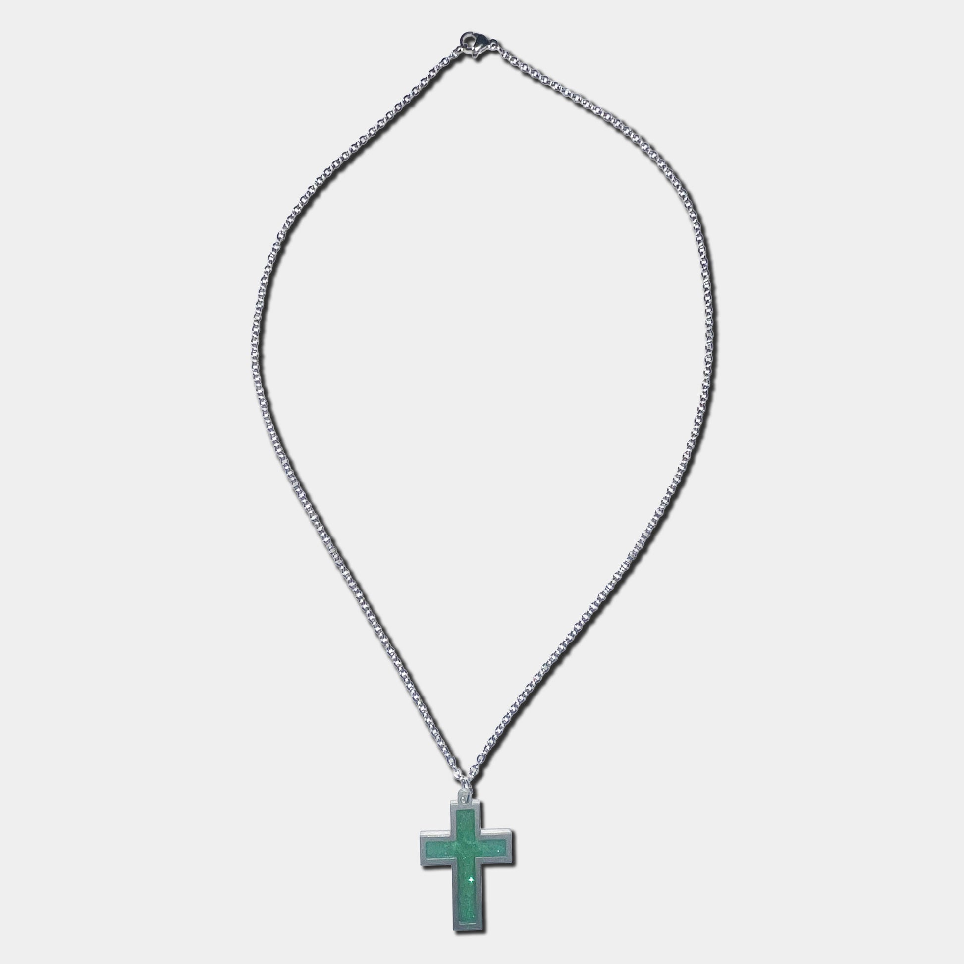 Stainless steel necklace with green cross pendant on a white background