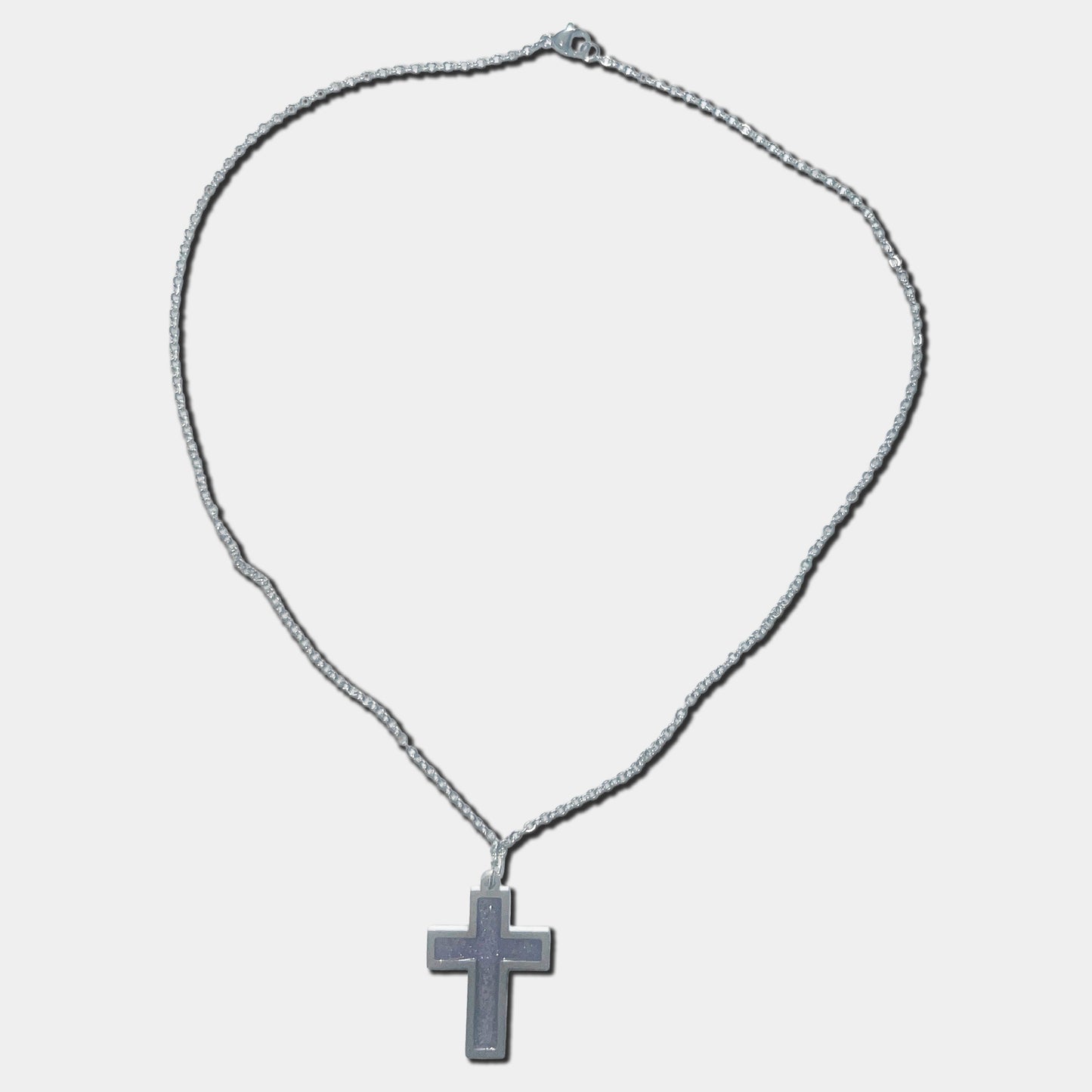 Stainless steel necklace with purple cross pendant on a white background