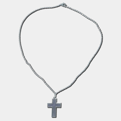 Stainless steel necklace with purple cross pendant on a white background
