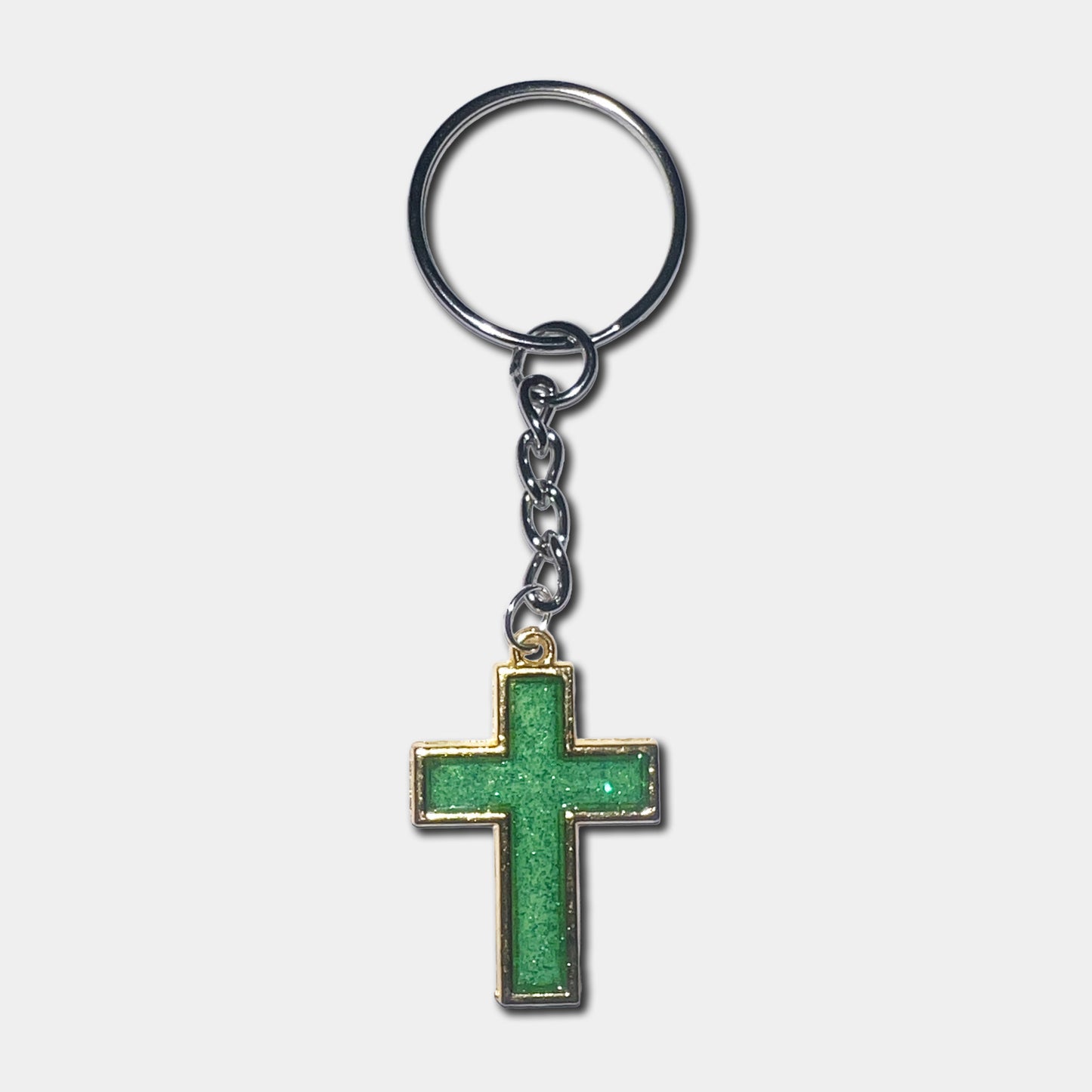 Keychain with a green cross pendant on a light gray background